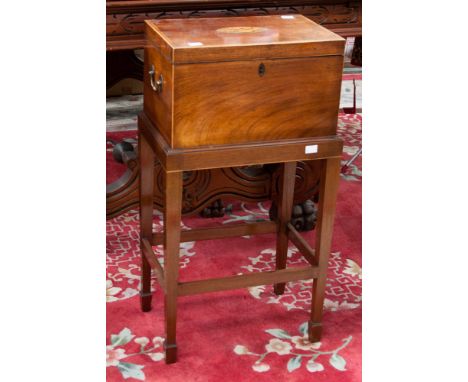 A George III mahogany tea caddy on stand, the tea caddy top inlaid with paterae to centre