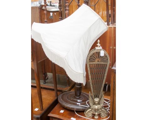 A standard lamp with cream shade and folding brass fire guard