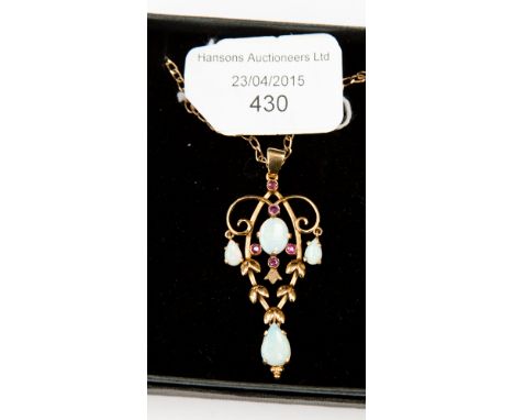 A 9ct gold and opal pendant on chain in the Art Nouveau style set with rubies, Birmingham