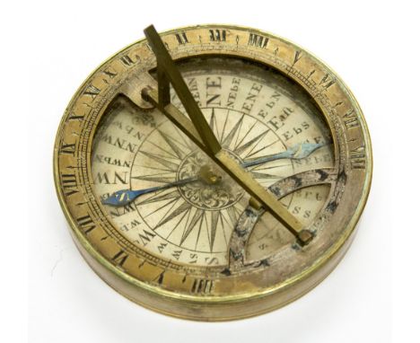 A circular brass compass with screw on lid