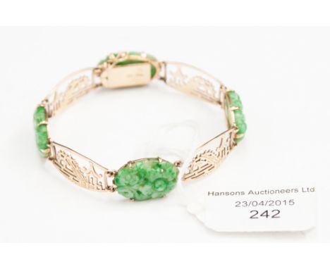 A 9ct and Jade bracelet set with four carved oval Jade and alternated with pierced oval links depicting pagoda landscape 