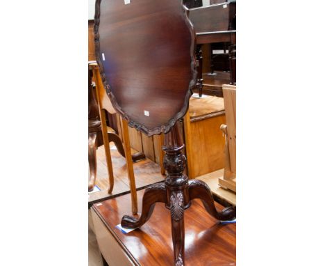 A George II style mahogany tripod table, the top a pie-crust edge, supported on a birdcage mechanism, raised on a turned colu