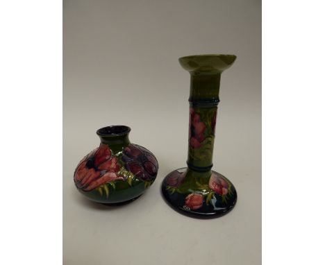 A Moorcroft bulbous vase, Hibiscus pattern on green ground, 11 cm high approx, with a Moorcroft candlestick, dark green groun