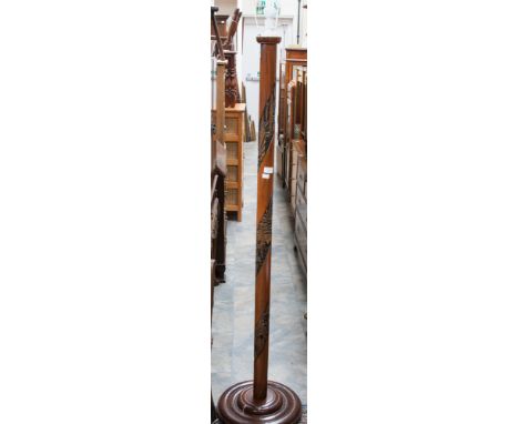 A carved Eastern standard lamp, the column with a spiral carved panel of decoration, raised on a circular base
