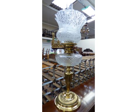 A late 19th century brass oil lamp with a cut glass reservoir, etched shade and funnel made by Maple, London