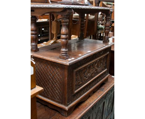 An oak carved monks bench, with carved back, top and front frieze