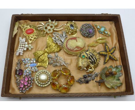 Nineteen costume brooches and a scarf clip 