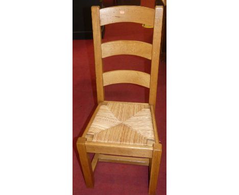 A set of eight contemporary honey oak ladder back rush seat dining chairs