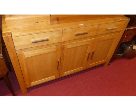 A modern light oak sideboard, fitted with three frieze drawers over conforming panelled cupboard doors, w.140cm 
