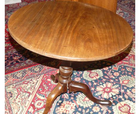 A 19th century mahogany circular tilt-top pedestal tripod table (one support with damages and requires restoration), dia. 70c