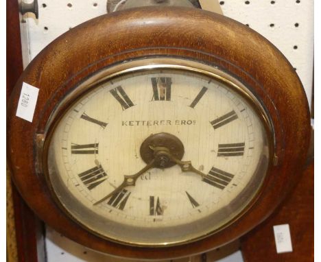 A Victorian mahogany circular postman's alarm clock, the white enamel dial signed Ketterer Brothers, with single weight and p