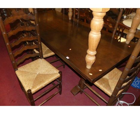 A large oak trestle end refectory dining table, length 217cm, together with a set of eight oak rush seat ladder back dining c