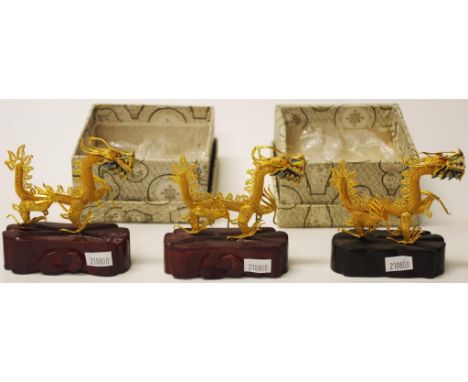 Group three Chinese decorative dragon figures each brass dragon figure with enamel decoration to head, on a fitted wood stand