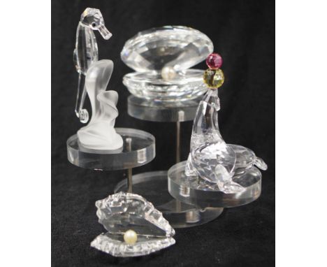 Four Swarovski crystal marine decorative figures including: 2 various oyster forms, with 'pearl' decoration; a seahorse figur