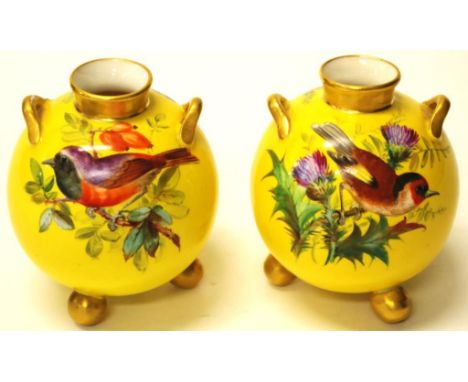 Pair of Victorian Royal Worcester ball form vases with handpainted bird and floral decoration, with twin gilt handles on thre