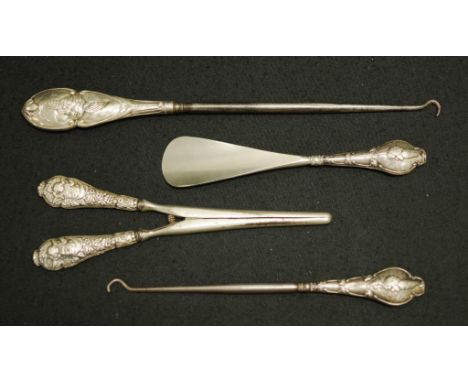 Four various sterling silver handle lady's pieces each with embossed decorated handle, (3 with cupid decoration), with early 