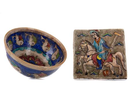 QAJAR POTTERY TILE,depicting a figure playing polo, 17cm x 17cm, along with a Persian pottery bowl decorated with fish (2)