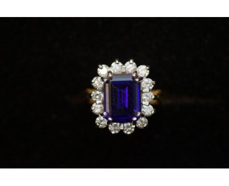 14ct gold dress ring set with central purple stone, surrounded by white stones