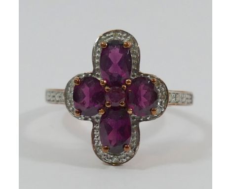A 9 carat rose gold almandine garnet and diamond cocktail ring, the five oval and circular mixed cut garnets claw set within 