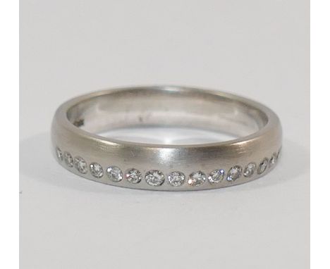  An 18 carat brushed white gold wedding band, London 2010, by Nick Kellett set with a a band of 16 small round brilliant cut 