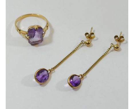 A yellow metal amethyst single stone ring, the emerald-cut amethyst in claw setting to three section shoulders, the shank sta