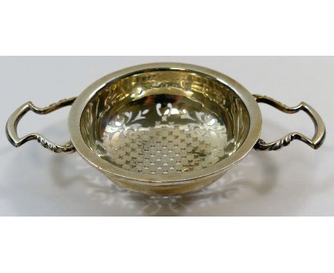 A George V silver two-handled strainer, Sheffield 1916 by Walker and Hall, 12.4cm across, 7.4cm diameter, 1.46ozt, 45.4g COND