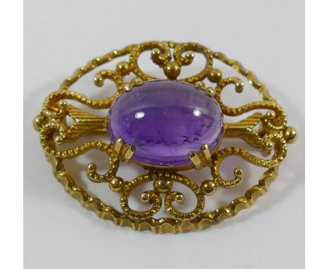A 9 carat gold oval openwork brooch set with a single cobochon amethyst, 3.6cm x 2.8cm, 10.5g gross CONDITION REPORT: If you 