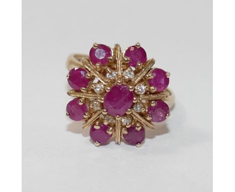A 9 carat gold ruby and diamond circular cluster ring, the circular and oval mixed cut rubies in claw settings, the centre st