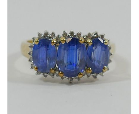 A yellow metal blue kyanite and diamond ring, the oval mixed cut kyanites in four claw settings within melee diamond surround