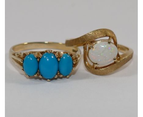 A 9 carat gold three stone turquoise set ring, with ornately pierced and cast gallery, finger size O 1/2, and a yellow metal 