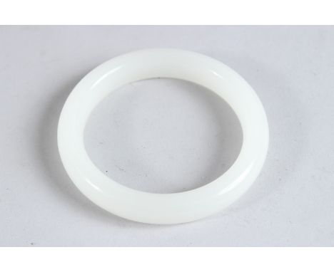 A CHINESE WHITE JADE CARVED BANGLE. 3.5ins diameter.