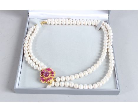A SILVER AND GOLD PLATED RUBY SET TWO ROW PEARL NECKLACE.