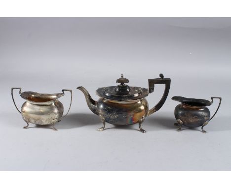 A SILVER TEAPOT on four legs, Sheffield 1912, including the handle, milk jug and sugar basin. Weight 26ozs.