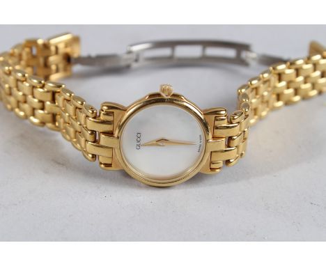 A LADIES' GUCCI GILT WRISTWATCH with mother-of-pearl face.