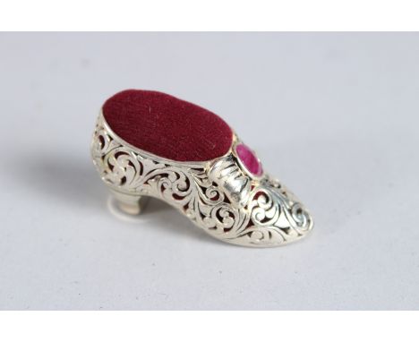 A SILVER RUBY SET SHOE PIN CUSHION.