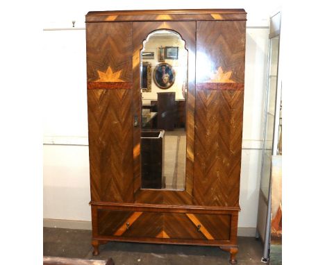 A 1930's Art Deco design walnut wardrobe, the interior enclosed by a mirrored panel door, a single drawer below raised on cab