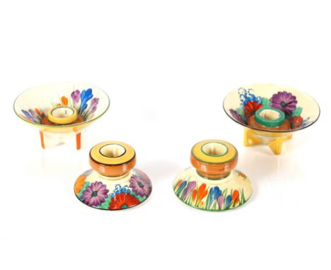 Two Clarice Cliff "Crocus" pattern candle stands; and two "Gay Day" pattern candle stands 