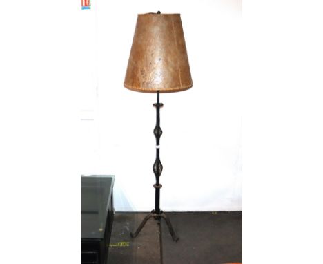 A wrought metal standard lamp, with pierced twist column and floral embossed hide lampshade