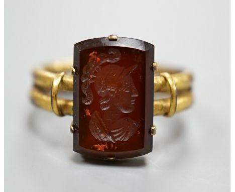 A 19th century yellow metal overlaid and rectangular intaglio chalcedony set ring, the matrix carved with the bust of a Roman