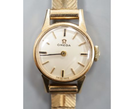A lady's 9ct Omega manual wind wrist watch, on a 9ct gold bracelet, gross weight 16.3 grams.