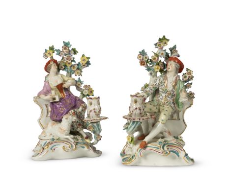 A pair of Samson candlestick figuresCirca 1900In the Derby style, each with a reclining figure against flowering branches, th