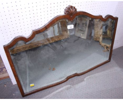 An early 20th century walnut shape frame mirror with bevelled glass and shell finial, 29 1/2" wide