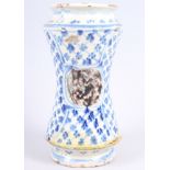 A 16th century albarello with blue and white decoration and "tortoiseshell" panels, 9 1/4" high (