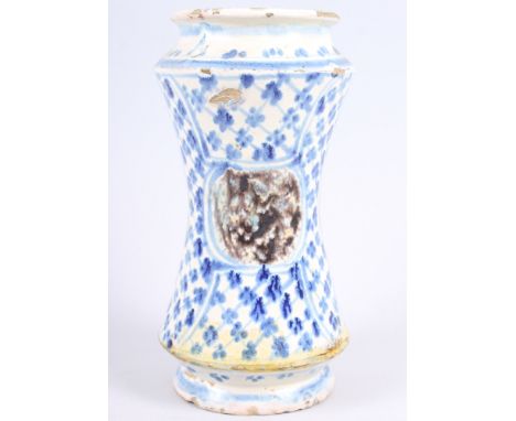 A 16th century albarello with blue and white decoration and "tortoiseshell" panels, 9 1/4" high (heavily restored)
