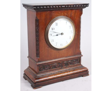 A mahogany cased mantel clock with carved decoration, white enamel dial and Arabic numerals