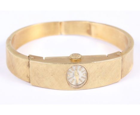 A Nadine Modele Depose yellow metal bangle watch, stamped 750, with textured surface, white enamel dial, baton numerals and 1