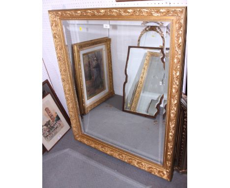 An ornate gilt framed wall mirror with bevelled glass, plate 39 1/2" x 29 1/2"