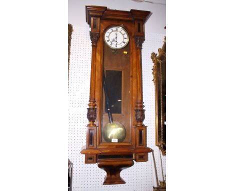 A 19th century walnut cased regulator type clock with white enamel dial and brass faced pendulums, 48" high
