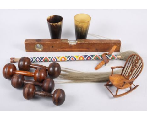 A pair of horn beakers, two pairs of turned wood dumbbells, a wooden mounted spirit level, a miniature Windsor wheelback rock
