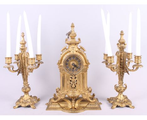 A Continental ormalu mantel clock with gilt dial and Roman numerals with two four-light garniture candelabra 